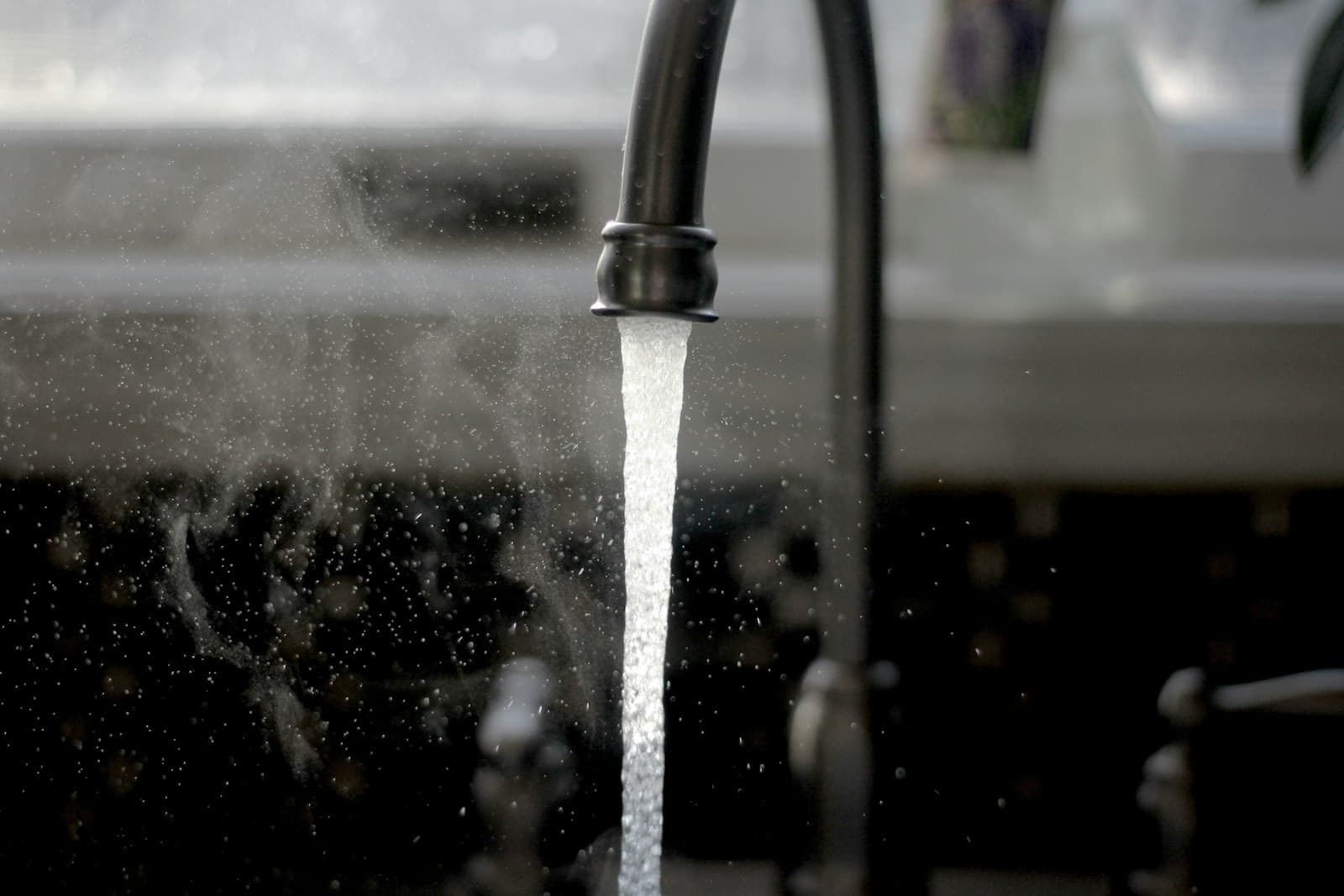 Stromend water uit een zwarte keukenkraan