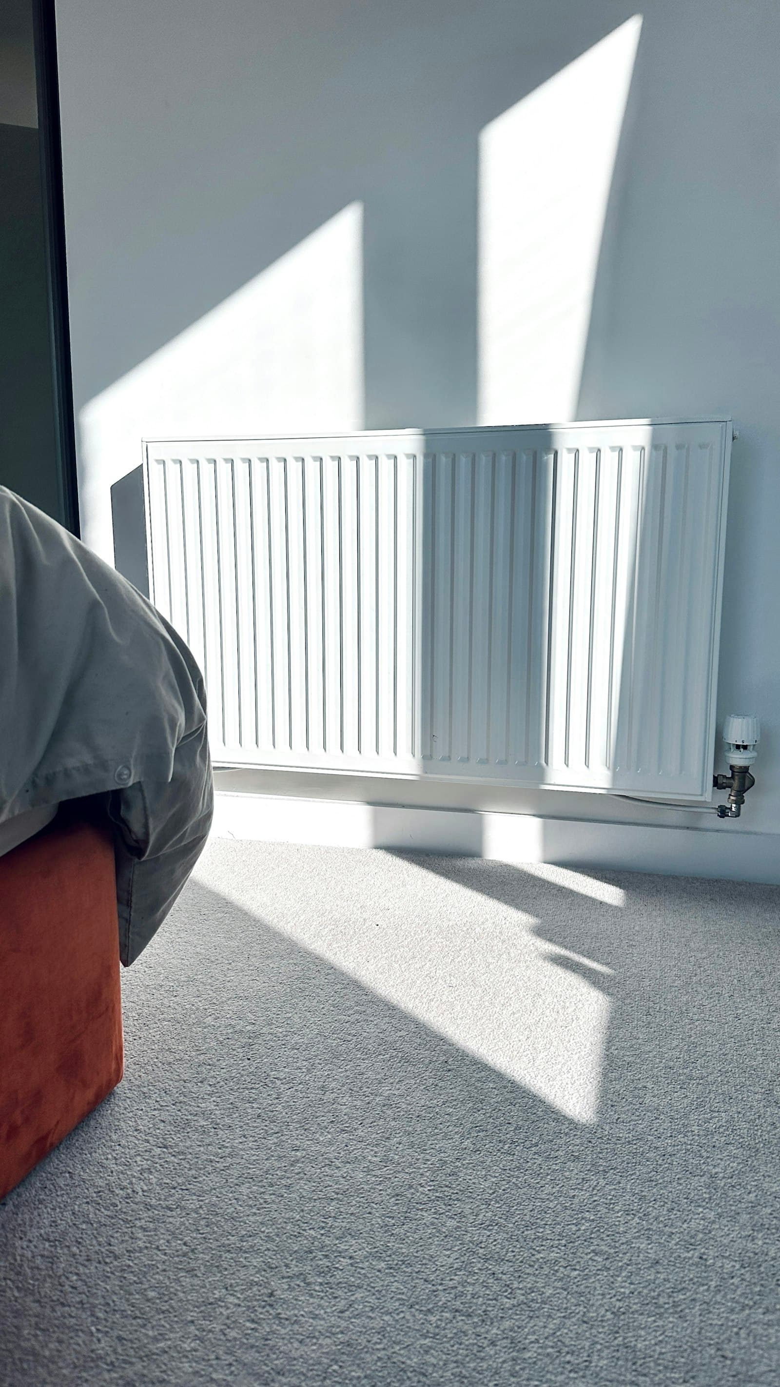 Slanke designradiator tegen een witte muur