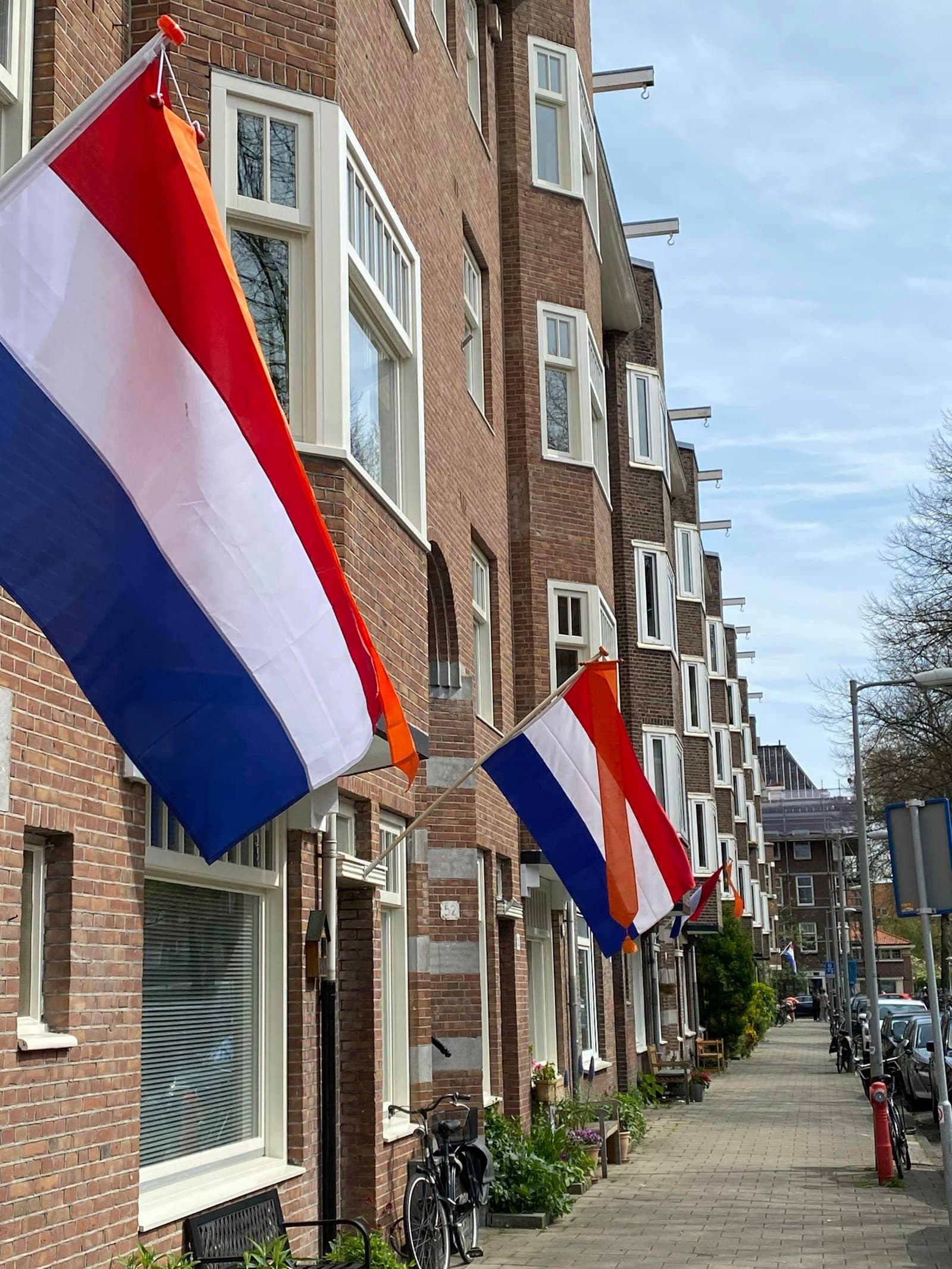 Nederlandse woonstraat met bakstenen woningen en vlaggen